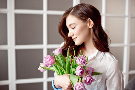 People, business, sale and floristry concept - close-up of florist woman holding bunch at flower shop.の写真素材
