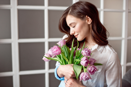 People, business, sale and floristry concept - close-up of florist woman holding bunch at flower shop.の写真素材
