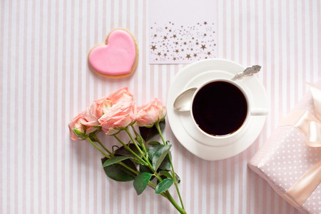 Valentines day celebration with cup of coffee and valentines decoration on pink tablecloth texture background.Top viewの写真素材