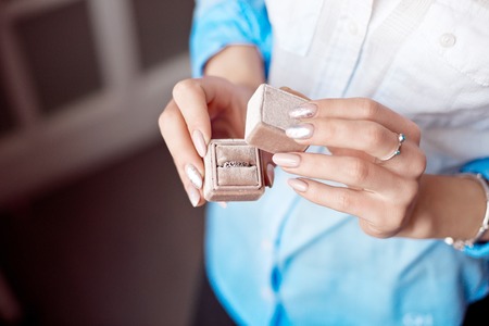 -Woman holding box with luxury ring on the window background, close-up.の写真素材