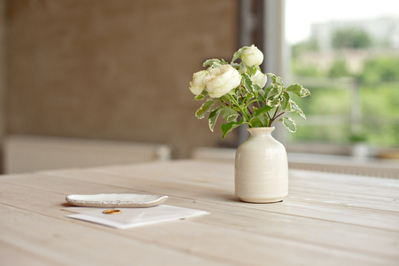 Wedding invitation birthday gift certificate for a spa or care decorated letter card on a white wooden table in front of a panoramic windowの写真素材