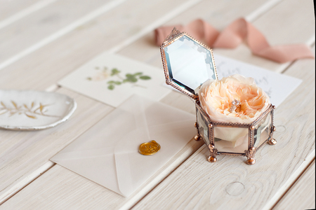 Wedding decor vintage glass square casket stand with peony rose inside and wedding ring invitation card.の写真素材