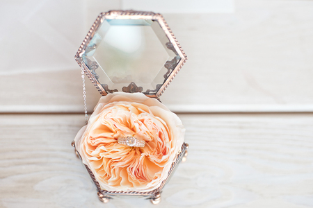 Wedding decor vintage glass square box with peony rose inside and wedding ring invitation card.の写真素材