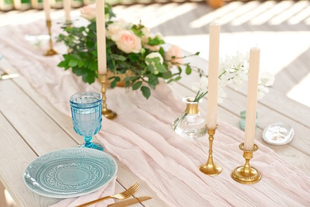Decorated table for dinner for two person, with plates knife, fork, cheese, wine, wine glasses and...