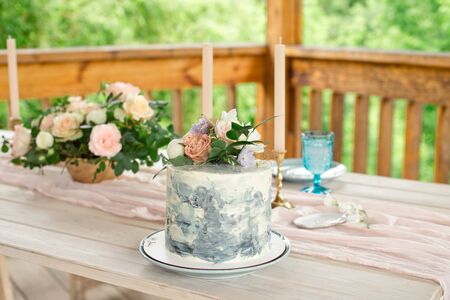 Wedding decoration table in the garden, floral arrangement, In the style vintage on outdoor. Wedding cake with flowers. Decorated table with flowers, served for two peopleの写真素材