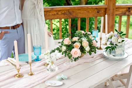Wedding decoration table in the garden, floral arrangement, candles In the style vintage on outdoor. Wedding cake with flowers. Decorated table with flowers, served for two people.の写真素材