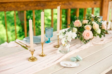 Wedding decoration table in the garden, floral arrangement,candles in the style vintage on outdoor....