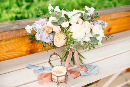 Close-up bouquet of roses peonies freesia dianthus flowers on the round white floore indoors.の写真素材