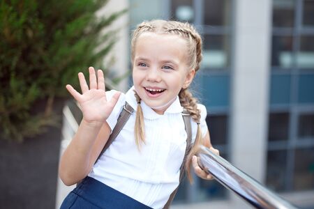 Happy smiling girl is going to school for the first time with bag go to elementary schoolの写真素材