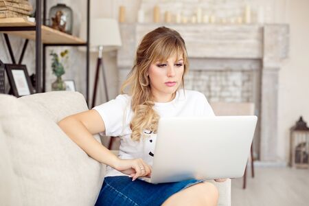 Beautiful young woman relaxing at home on her laptop computer.の写真素材