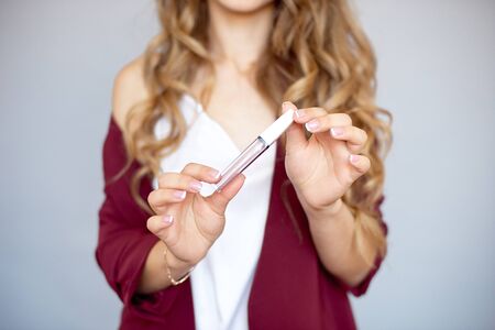 Cosmetics for beauty. Cosmetics. Close-up of a beautiful young woman with glamorous eye makeup, fashionable hairstyle, holding a makeup brush.の写真素材