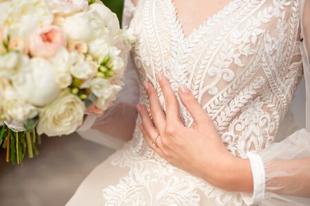 Close-up of a delicate ring on the bride's hand with pale pink nailsの写真素材