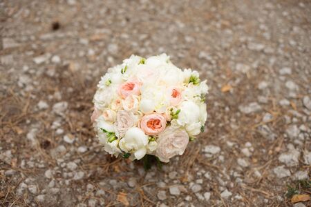 Wedding bouquet lying on grey carpet during preparation before celebration. Side view of decorative rose,peonies flowers and leaves bouquetの写真素材