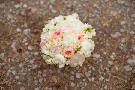 Wedding bouquet lying on grey carpet during preparation before celebration. Side view of decorative rose,peonies flowers and leaves bouquetの写真素材