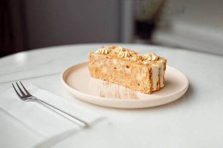 Coffee cake. A piece of cake on a plate. Sweet dessert on a round pink with a plate wooden background. Close-upの写真素材