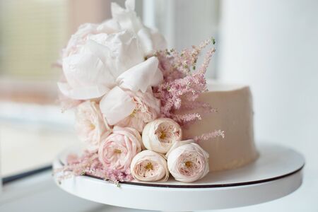 Decorated with fresh flowers, white naked cake, a stylish cake for weddings, birthdays and events.の写真素材