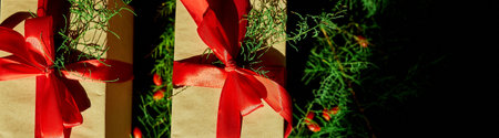 bANNER   Christmas eco friendly packaging kraft paper and fir branches gifts for the Holiday season on black backgroundの写真素材