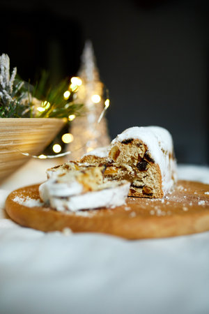 Homemade traditional marzipan Christmas Stollen on white background, with christmas lights and decorationsの写真素材