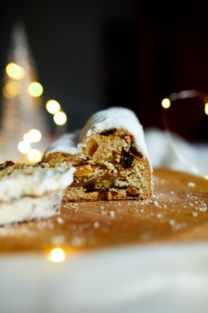 Homemade traditional marzipan Christmas Stollen on white background, with christmas lights and decorationsの写真素材