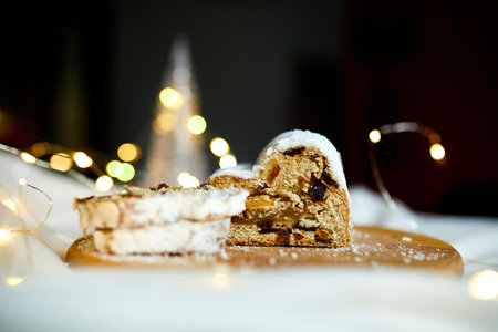 Homemade traditional marzipan Christmas Stollen on white background, with christmas lights and decorationsの写真素材