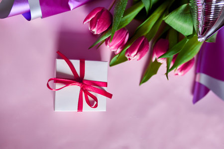 Top view pink tulips flowers in violet paper wrapper with gift box, festive background, concept of Happy Mother's day, Woman's day, birthday, 8 March, Valentines dayの写真素材