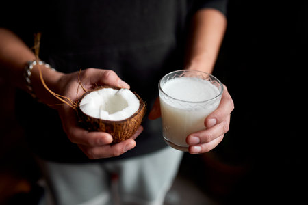 Male hands with glasse of vegan coconut milk, Alternative types of non-dairy milks, plant milk made of various grain, Clean eating, Healthy diet.の写真素材
