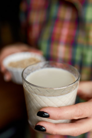 Female hands with glasse of vegan oat milk, Alternative types of non-dairy milks, plant milk made of various grain, Clean eating, Healthy diet.の写真素材