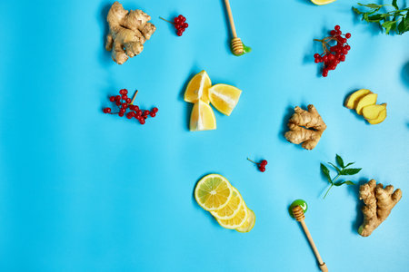 Flat lay of Immune boosting remedy, immunity boosting foods ginger, lemon,  honey,  guelder rose, mint on blue background Top view, copy spaceの写真素材