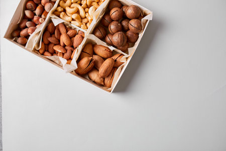 Assorted nuts in a wooden box nuts: pecan, almond, macadamia, brazil, cashew, hazelnut, Rich in minerals and protein. Healthy nutrition, high in zinc, magnesium and vitamins, online ordering, shoping concept.の写真素材