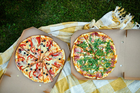 Two pizzas in the food carton on the grass, picnic concept, top view, copy space. Take away food, fastwood, italian pizza outdoor.の写真素材