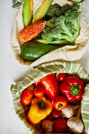 Top view assorted fresh vegetables in reusable cotton bags on table in the kitche in sunlight, groceries in textile Zero waste bags, Online grocery healthy shopping, vegan food.の写真素材