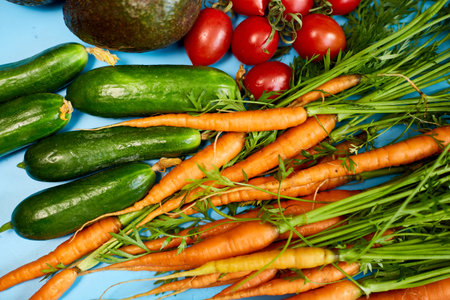 Flat lay vegetables, carrots, cucumbers, avocados, tomatoes on the biege background, grocery...