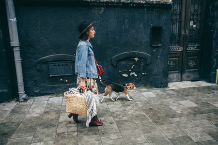 woman walking her beagle dog in townの写真素材