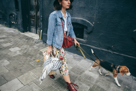 woman walking her beagle dog in townの写真素材