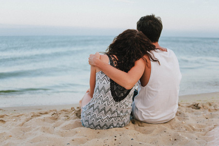 Beautiful girl and man at sunset on sandy bechの写真素材