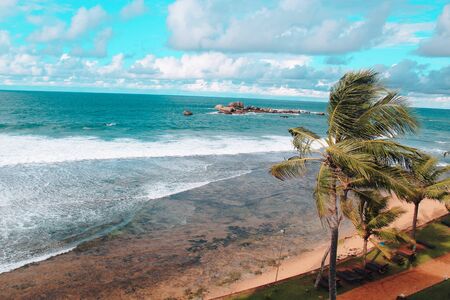A bewitching ocean view with palm trees, bright blue sky and green-blue water. Travel, tourism concept.の写真素材