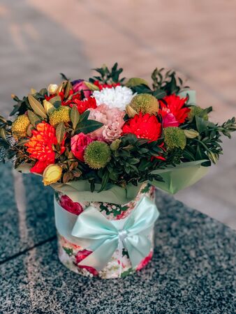 A bouquet of flowers from chrysanthemums, eustomas, roses in a box with a menthol bow.の写真素材