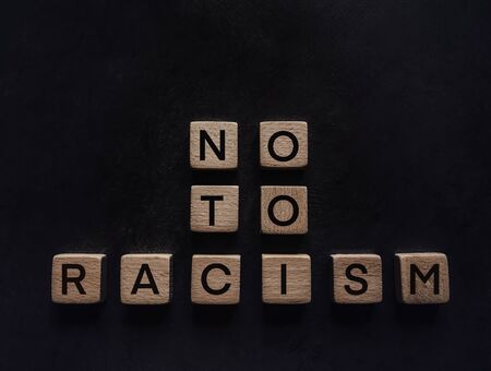 Inscription of wooden letters no to racism on a black background.の写真素材