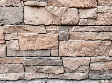 Close-up of texture of facing brick in gray and beige tones in the decoration of the building. Construction and architecture concept.の写真素材
