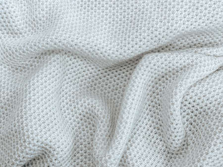 The texture of a knitted white warm sweater with slightly gathered folds.の写真素材