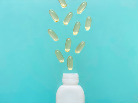 Omega-3 capsules levitating over a medicine bottle on a turquoise background. Healthy lifestyle.の写真素材