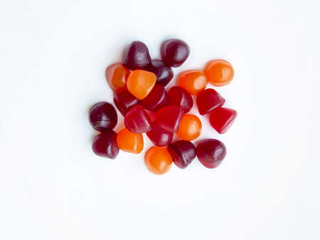 Group of red, orange and purple multivitamin gummies isolated on white background. Healthy lifestyle...