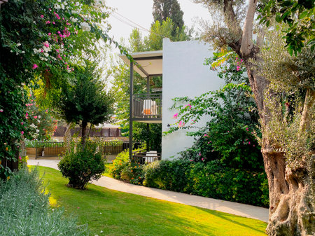 The territory of the hotel in the resort town with an incredibly beautiful garden, beautiful flowering shrubs and fruit trees. The building on the territory of the hotel, the concept of recreation and tourism.のeditorial素材