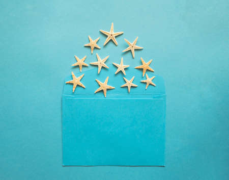 Blue envelope with many sea stars inside on a blue background.
