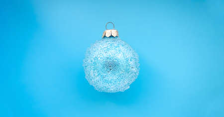 blue christmas ball with some bumps on a blue background. Minimal Christmas design, place for text