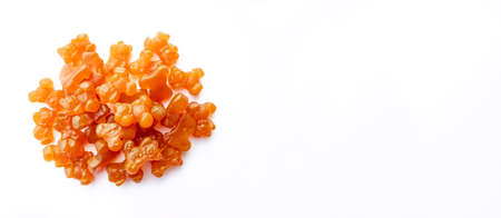 Close-up texture of orange and yellow multivitamin gummies in the form of bears on white background.の写真素材