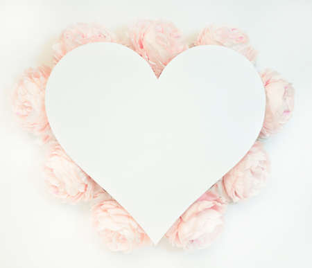 Flowers composition from pink flowers in the form of a heart on white background. Spring, summer template for your projectsの写真素材