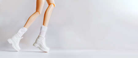 Physical activity and health. Dolls legs in white sneakers depicting running or movement