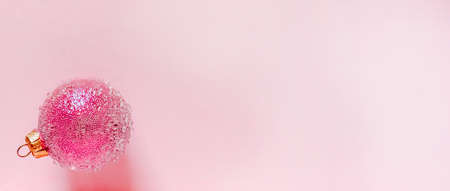 Pink christmas ball with some bumps on a pink background. Minimal Christmas design, place for textの写真素材