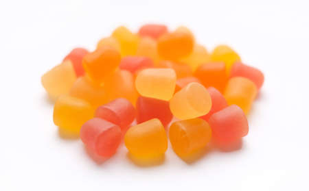 Close-up texture of orange and yellow multivitamin gummies in the form of bears on white background.の写真素材